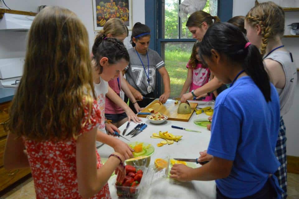 Campers and staff cutting up fruit