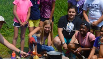 Learning how to cook over a fire at WeHaKee Camp for Girls