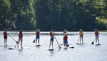 WeHaKee Camp for Girls paddle boarding on Lake Hunter.