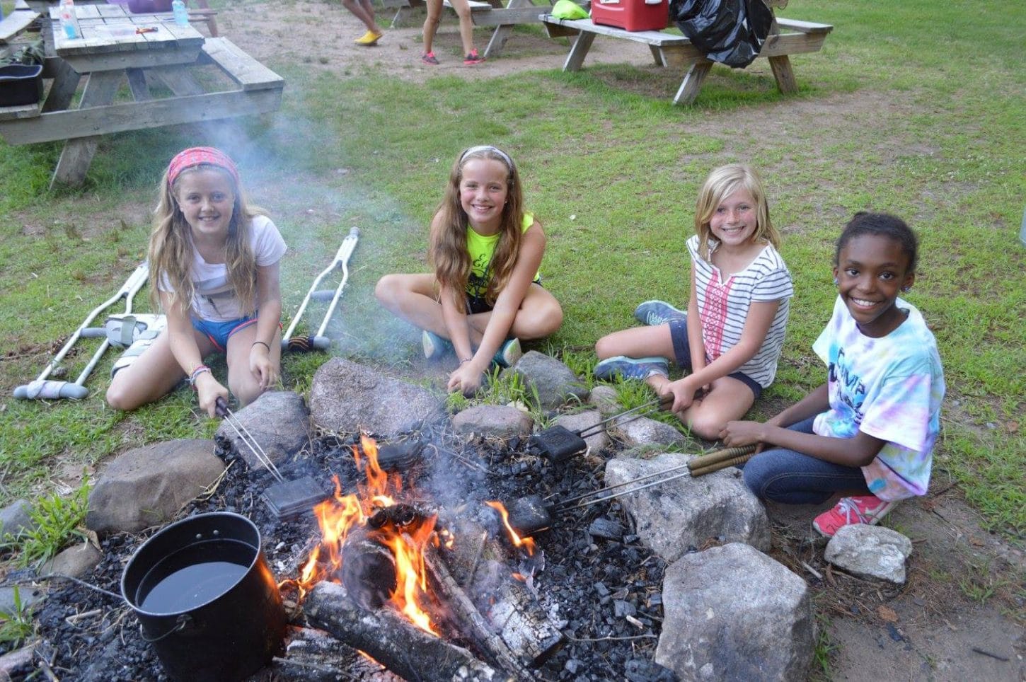 Campers making pudgy pies in the fire at WeHaKee Camp for Girls.
