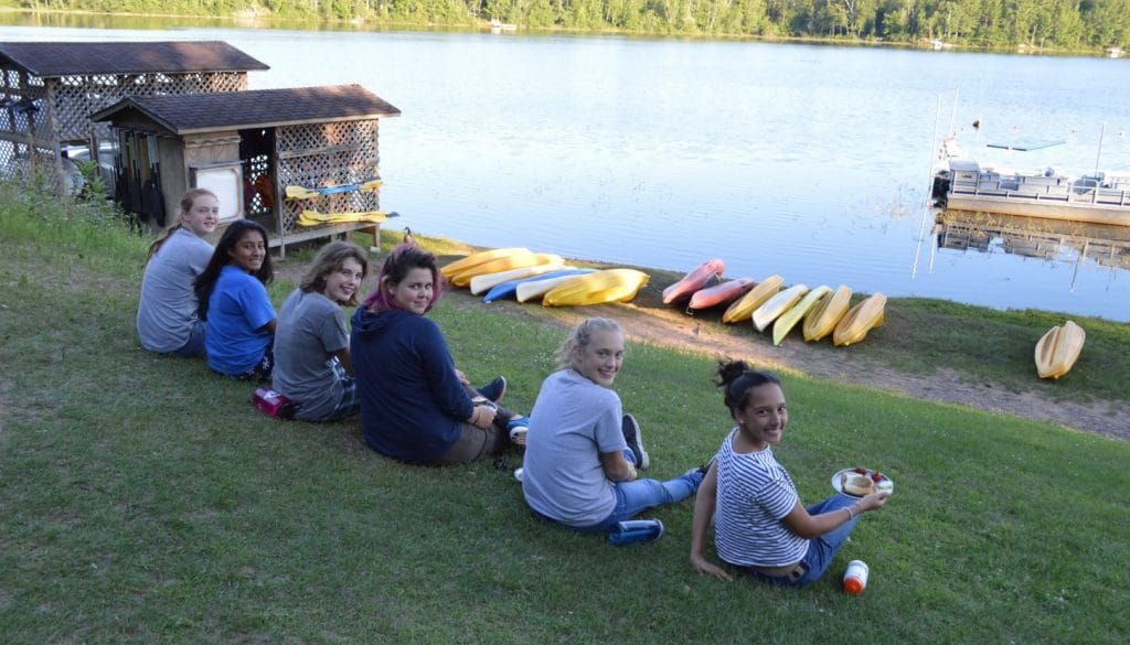 Campers enjoying lunch in front of Hunte Lake at WeHaKee Camp for Girls.