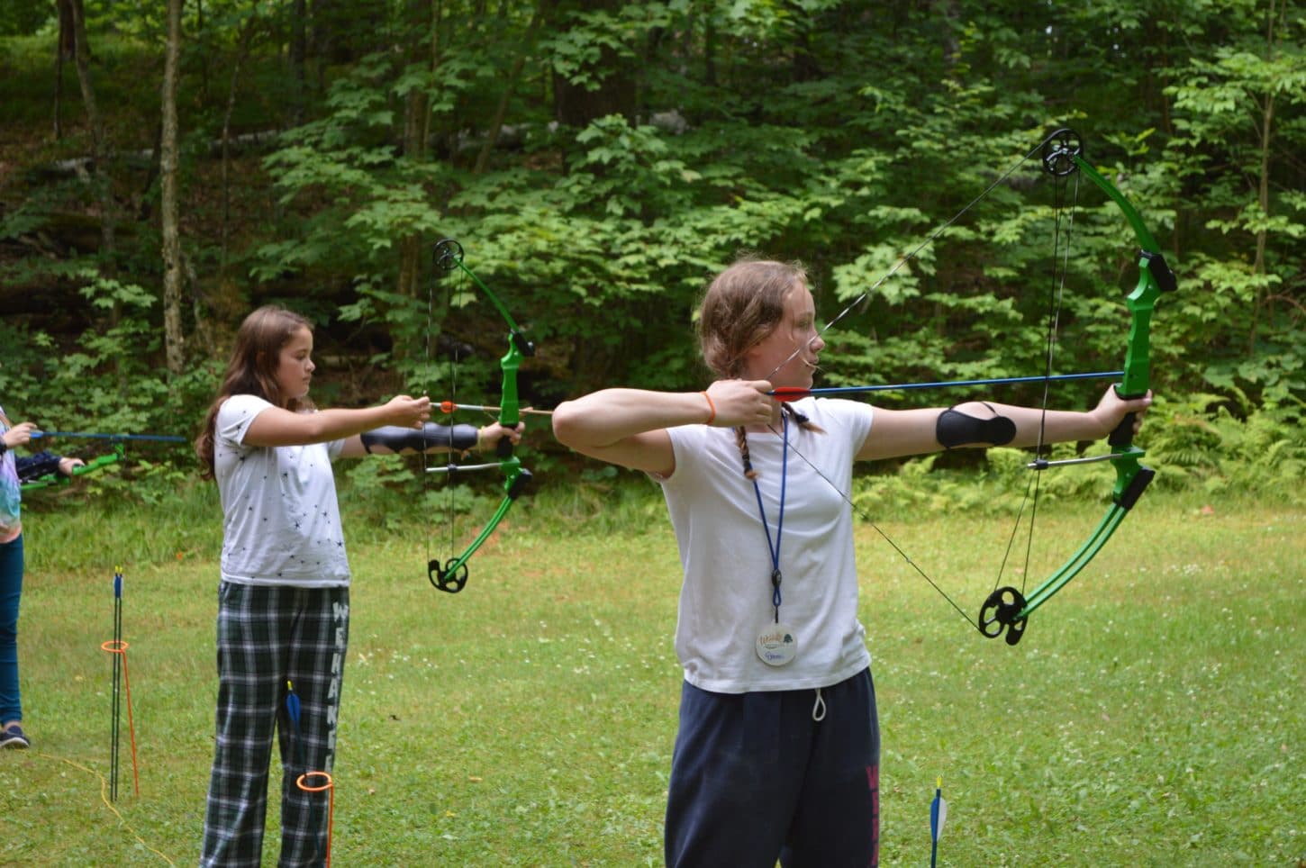 Campers practicing shooting bow and arrow and WeHaKee Camp for Girls.