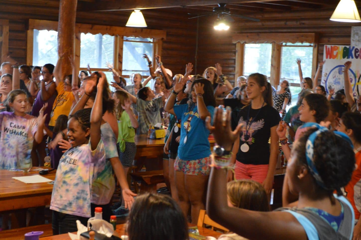 WeHaKee Camp for Girls campers singing and having fun indoors.