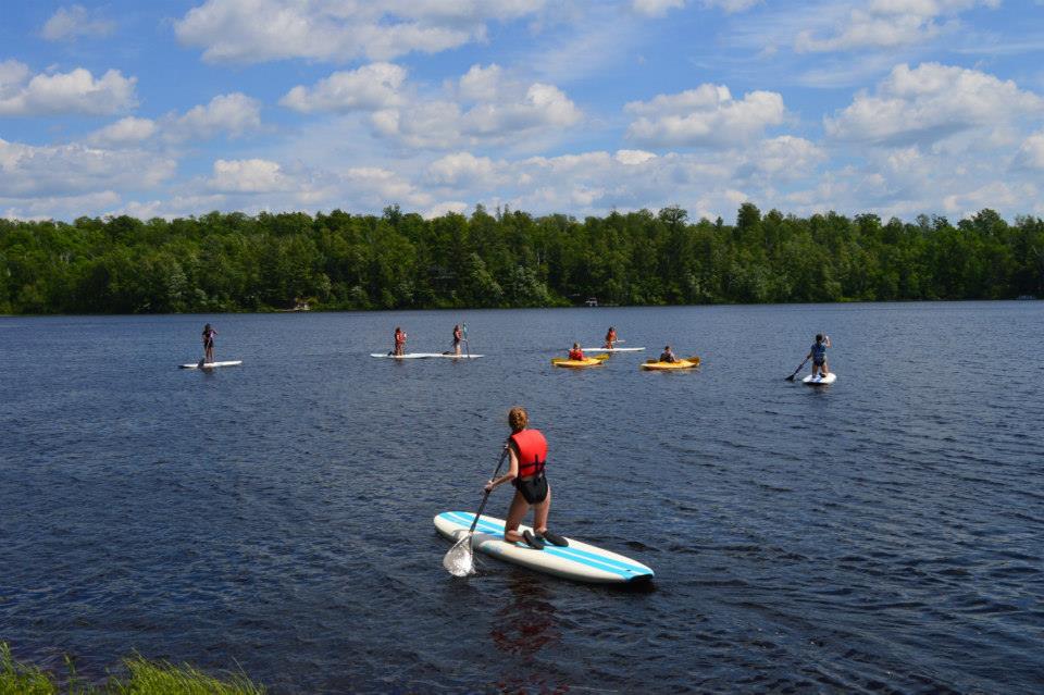 WeHaKee Camp for Girls campers paddleboarding and kayaking.
