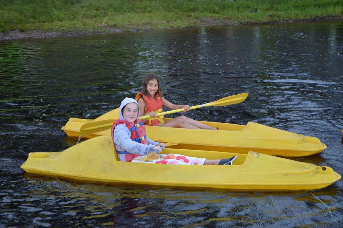 Two WeHaKee campers having fun on the lake in their yellow kayaks