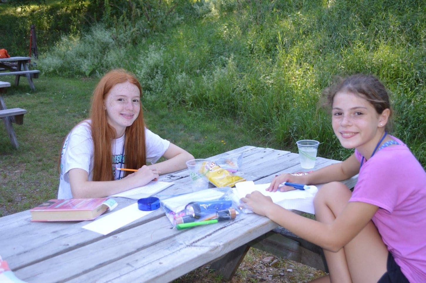 Two WeHaKee campers enjoying time together on a picnic table