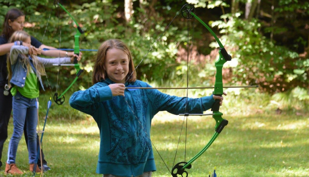 WeHaKee Camp for Girls happy camper with a bow and arrow.