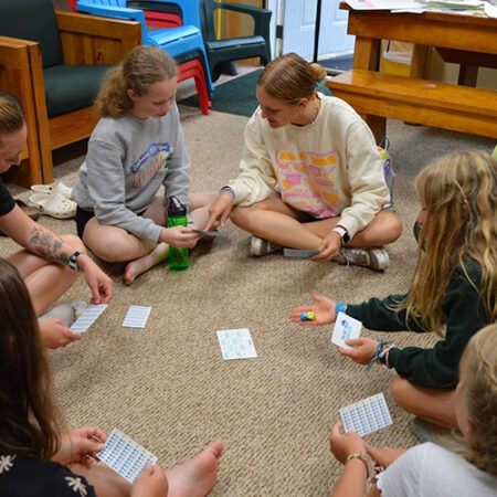 wehakee-camp-for-girls-campers-dice-game-rules-activity-building-skills-friendships-2024-winter-wisconsin