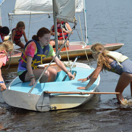 wehakee-camp-for-girls-campers-sail-boating-pushing-off-shore-guidance-2024-hunter-lake-winter-wisconsin